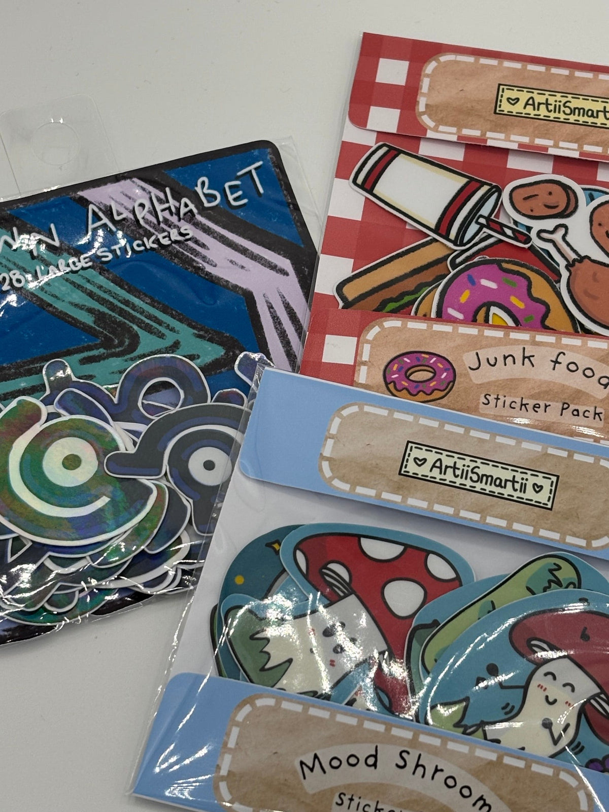 3 sticker packs, sticker flakes, featuring junk food stickers, mood shroom stickers and unown alpphabet stickers