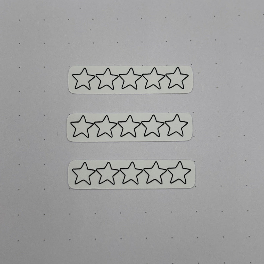 Three white rectangular stickers, each printed with five outlined star icons, arranged vertically on a light gray surface.