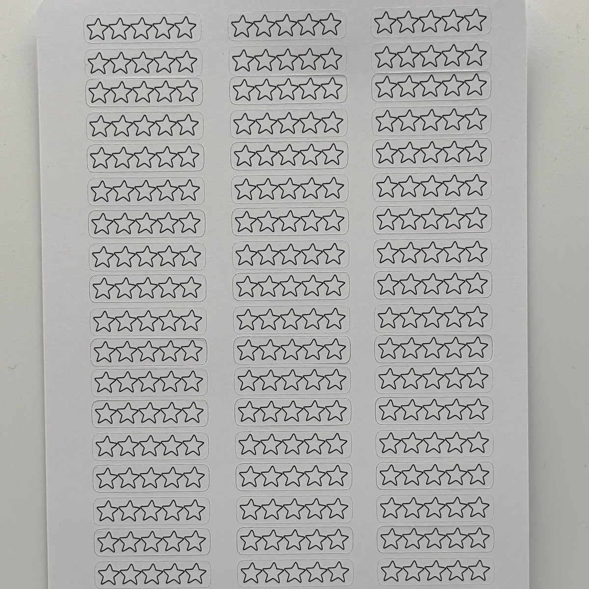 A white rectangular sticker sheet featuring rows of small outlined star stickers and a gray horizontal band at the bottom with a circular Art of Smart 44 logo.